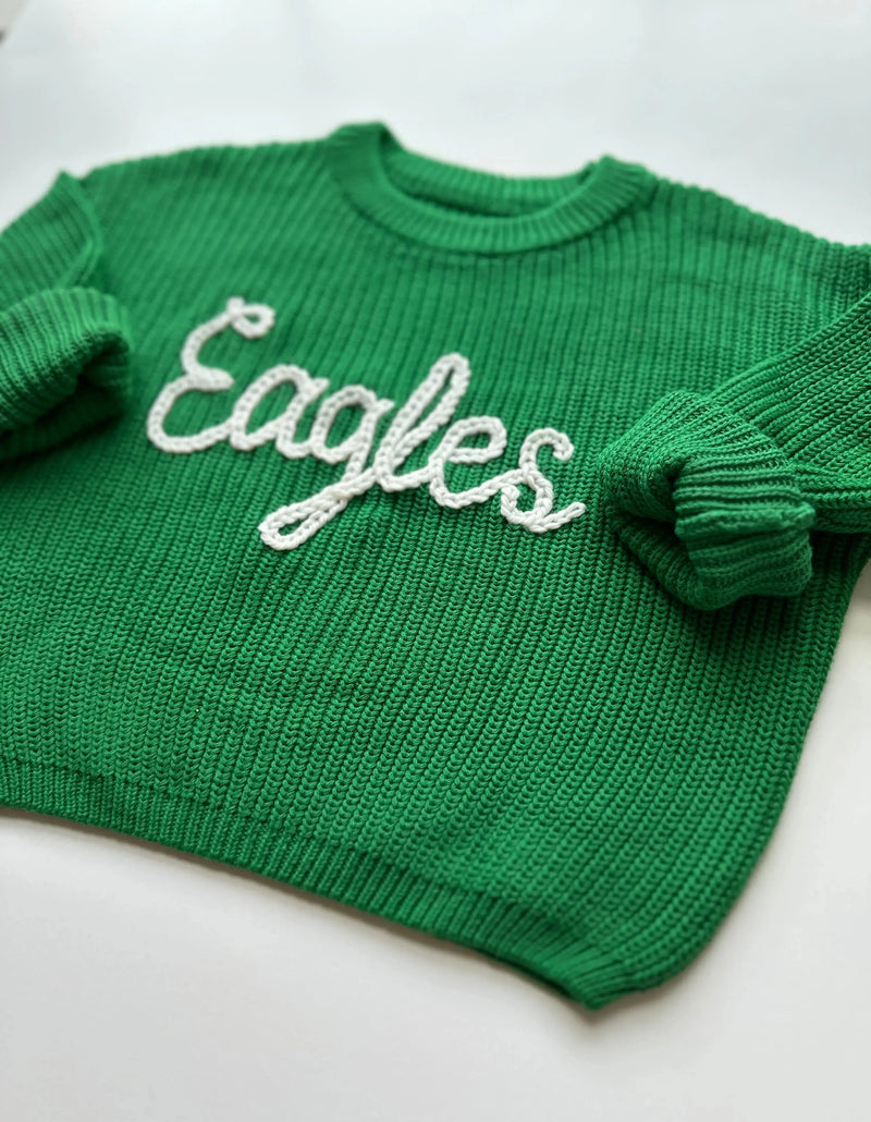 Green sweater with 'Eagles' text on a white background