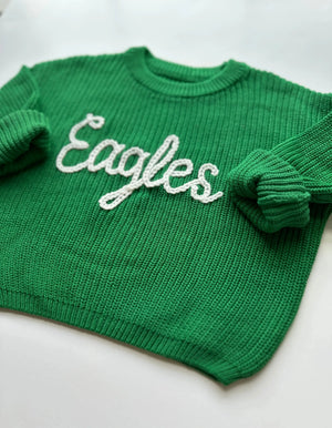 Green sweater with 'Eagles' text on a white background