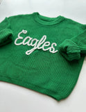 Green sweater with 'Eagles' text on a white background